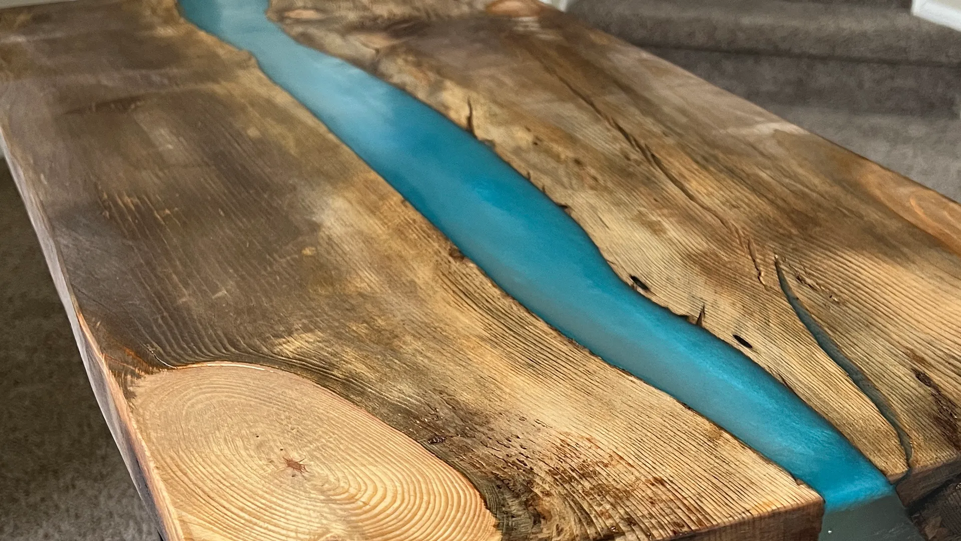 Live-edge pine dining table with blue epoxy river inlay, handcrafted by Steve Hayton